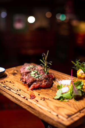 Entrecote Beef Grilled steak meat on wooden cutting boardon with rosemary branch, pepper and salt .の写真素材