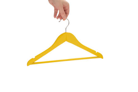 Yellow hanger in woman hand isolated on white.の写真素材
