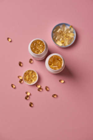 Many transparent pills Omega 3 or fish oil on a colorful background. Health supplements and medicinesの写真素材