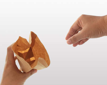 hand holding a brown paper bagの写真素材