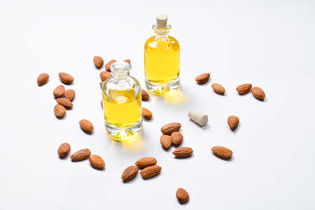 Bottles of almond oil and almonds on white background, copyspace.の写真素材