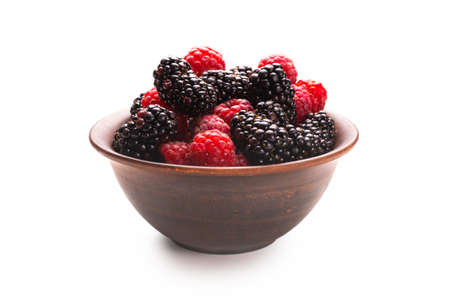 Raspberry, blackberry and mint leaf in ceramic brown bowl isolated on whiteの写真素材