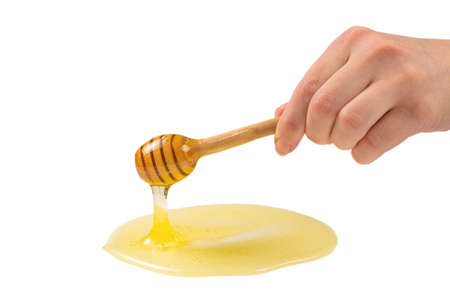 Dipper with honey in woman hand.の写真素材