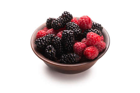 Raspberry, blackberry and mint leaf in ceramic brown bowl isolated on whiteの写真素材
