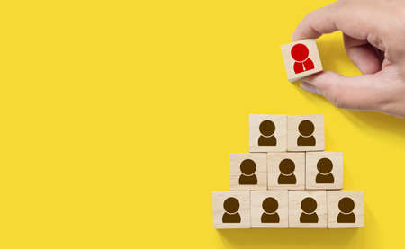 Human resource management and recruitment business concept, Hand putting wood cube block on top pyramid, Copy spaceの写真素材