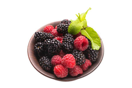 Raspberry, blackberry and mint leaf in ceramic brown bowl isolated on whiteの写真素材