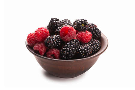 Raspberry, blackberry and mint leaf in ceramic brown bowl isolated on whiteの写真素材