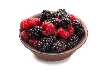 Raspberry, blackberry and mint leaf in ceramic brown bowl isolated on whiteの写真素材