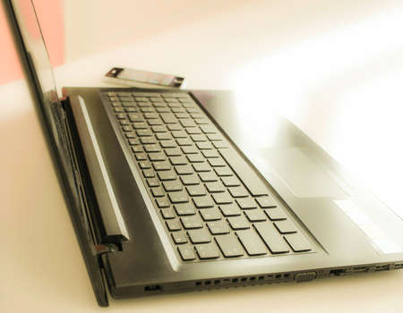 Close up detail side view of a laptop computer keyboard with the daytime soft light shining high contrastの写真素材
