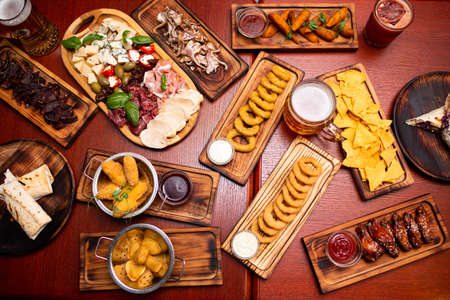 Assorted beer snacks, fast food. Fried Cheese Sticks, cured meats, nuggets with mug of beer.の写真素材