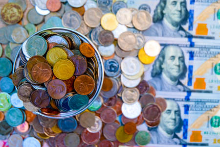 Close up heap of coins lay on US dollar and Chinese Yuan banknote.の写真素材