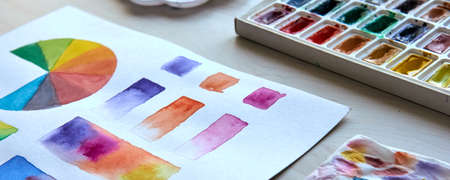 Artists workplace. Art supplies brushes, paints, watercolors. Art studio. Drawing lessons. Creative workshop. Design place. Watercolor color wheel and palette. Color theory beginner hobby lessonsの写真素材
