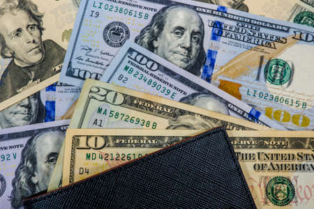 Pile of many US dollar banknote with black wallet as money background for investment saving and shopping concept.の写真素材