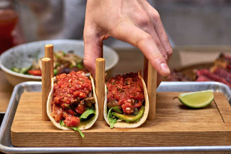 Traditional street mexican pork tacos with beef, tomatoes, avocado, chilli in yellow corn tortillaの写真素材