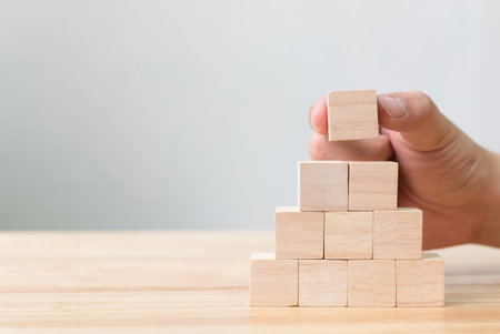 Hand arranging wood block stacking as step stair. Business concept for growth success processの写真素材