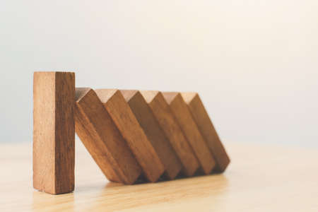 Business risk management concepts. Wooden block stop falling of other pieces of domino effect.の写真素材