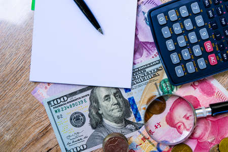 Empty blank notebook with colorful international banknotes and calculator.の写真素材