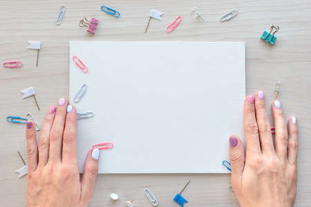 School office supplies on wooden background. Back to school concept. White board with hands for copy space. Top view ready for your designの写真素材