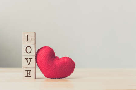 Valentines day concept, Wood cube block with text love and red heart on wood tableの写真素材