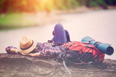 Hipster traveler sleep relaxation on the rock lakeside in travelling of herの写真素材