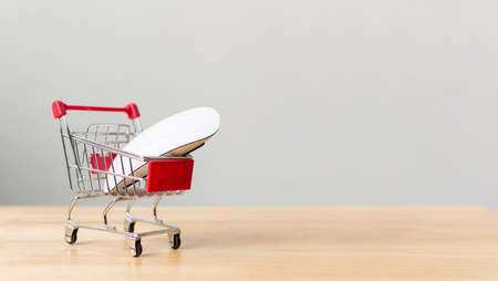 Online shopping and ecommerce transport logistics delivery service concept. Computer mouse on shopping cart on wood table. Copyspace for your textの写真素材