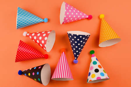 Colorful birthday caps on orange background. Top view.の写真素材