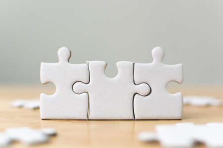 White jigsaw puzzle connecting together. Team business success partnership or teamwork conceptの写真素材