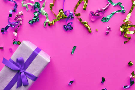 Christmas composition. Giftbox with ribbon and confetti decorations on pastel paper colorful background. Christmas, winter, new year celebration concept. Flat lay, top view, copy spaceの写真素材