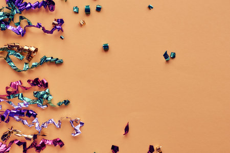 Party colorful confetti over pastel paper background. Sparkles, glitter, tinsel elements new year celebration frame. Flat lay, top view, copy space bannerの写真素材