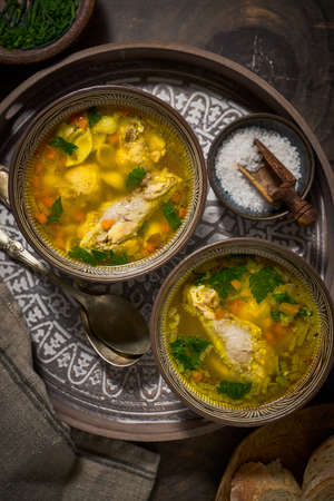 Asian style chicken soup in two clay bowls, top viewの写真素材