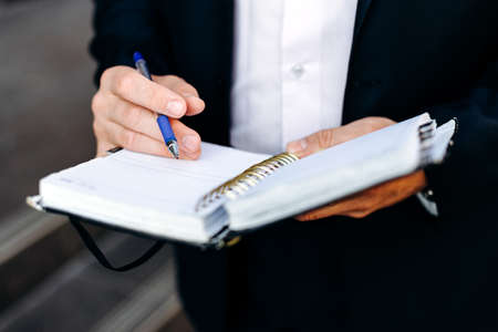 closeup male hand with a pen and notebook. Written a note. - Imageの写真素材