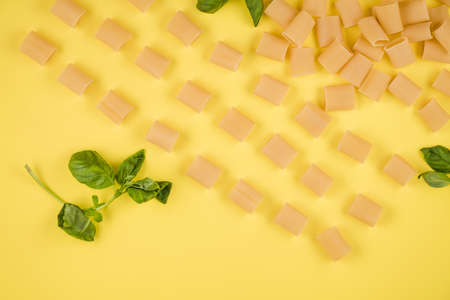 The yellow background shows Italian paste, basil. concept of italian cuisine.の写真素材