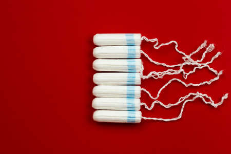 Menstrual period concept. Woman hygiene protection. Womens health. Cotton tampons on red background.の写真素材