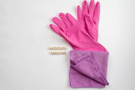 Pink latex gloves and .rag lying on a white background. Concept cleaning service