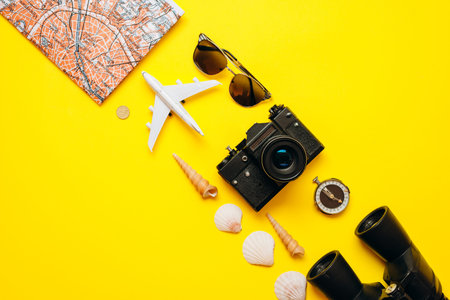 On a yellow background on a diagonal important things are laid out: sunglasses, binoculars, the...