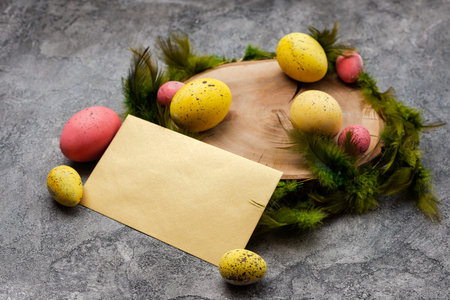 Empty mockup blank on a Easter background. Colorful eggs and feathers on the wooden stump. -...