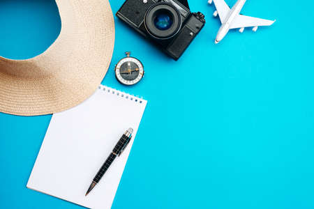 Summer vacation concept, on blue background hat, notebook, pen, compass and airplaneの写真素材