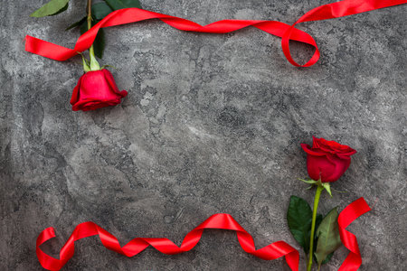 Valentines Day or other love holiday. On a gray background, red trojans are decorated with red ribbon, top viewの写真素材