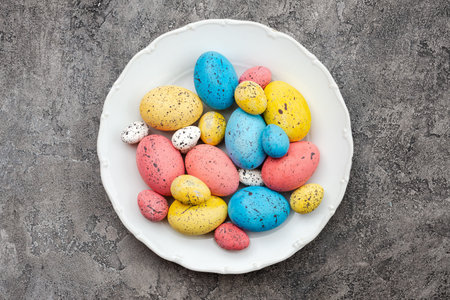 Colored easter eggs on plate on a gray plaster background. - Copyspace