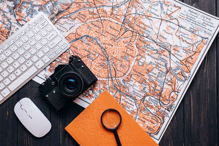Keyboard, computer mouse, maps, notebook and camera, holiday travel plans.の写真素材