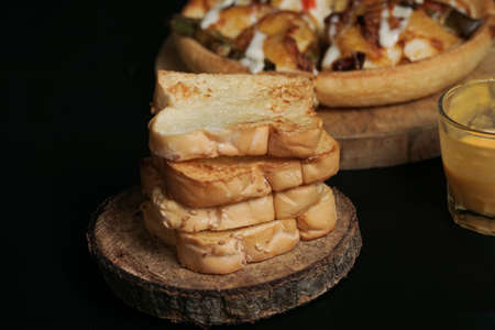 a pile of toasted white bread on the wooden paddleの写真素材