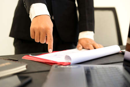 a man is pointing his finger firmly at his paperの写真素材