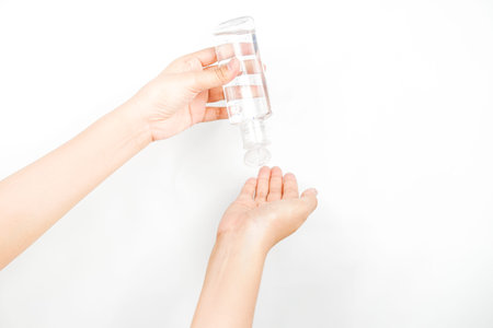 pouring a liquid from a transparent bottle into a handの写真素材