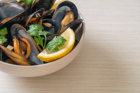 Mussels with herbs in a bowl with lemonの写真素材