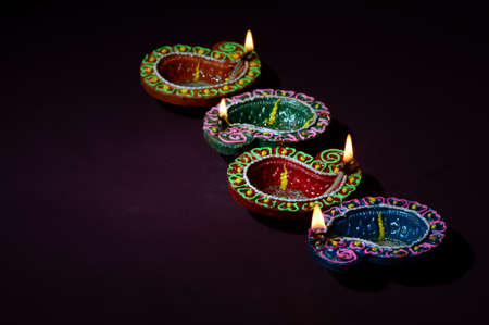Colorful clay Diya (Lantern) lamps lit during Diwali celebration. Greetings Card Design Indian Hindu Light Festival called Diwali.の写真素材