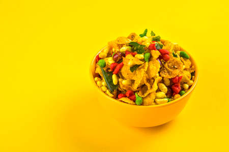 Indian Snacks: Traditional Indian deep fried salty dish called chivda or mixture or farsan made of gram flour and mixed with dry fruits and roasted nuts with salt, pepper, pulses, spice and green peasの写真素材
