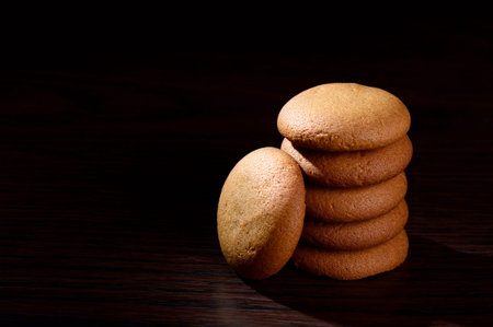 BISCUITS - Stack of delicious cream biscuits filled with chocolate cream on black background