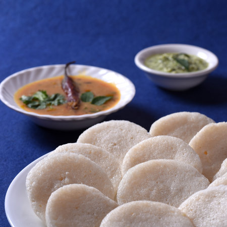 Idli with Sambar and coconut chutney on blue background, Indian Dish : south Indian favourite food rava idli or semolina idly or rava idly, served with sambar and green chutney.の写真素材