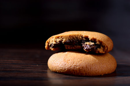 Biscuits filled with chocolate cream. Chocolate cream cookies. brown chocolate biscuits with cream filling on black background.の写真素材