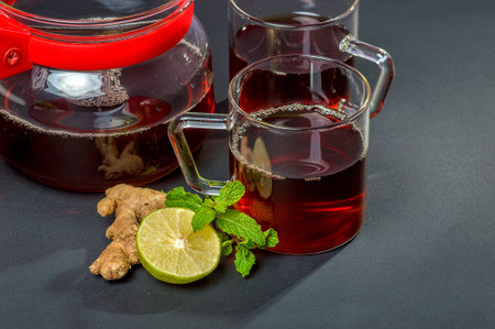 Cup of tea, mint and lemon on dark background